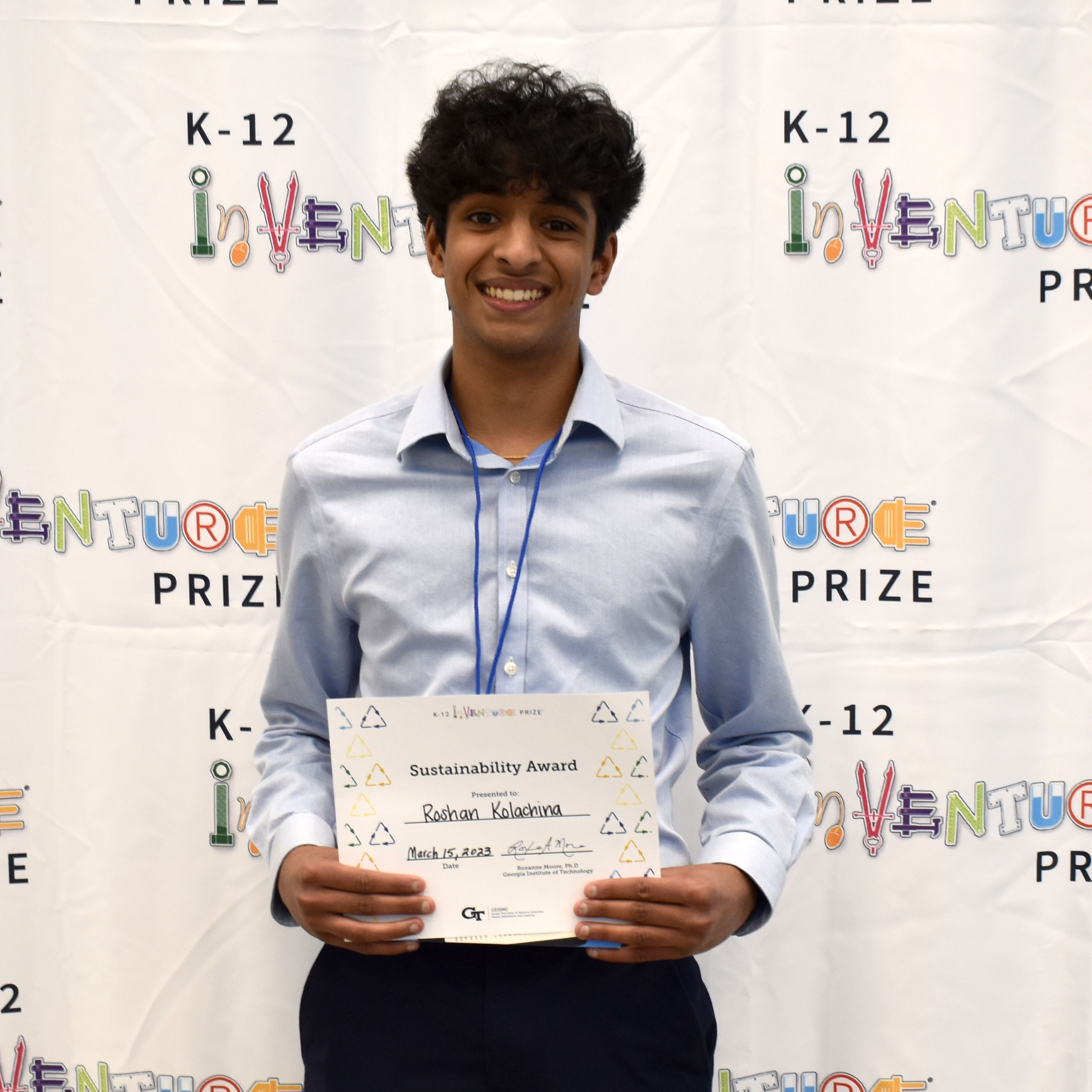 A smiling student holding up a certificate