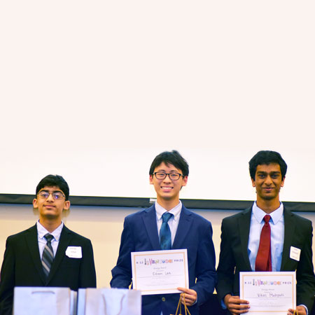 Three smiling students holding up certificates