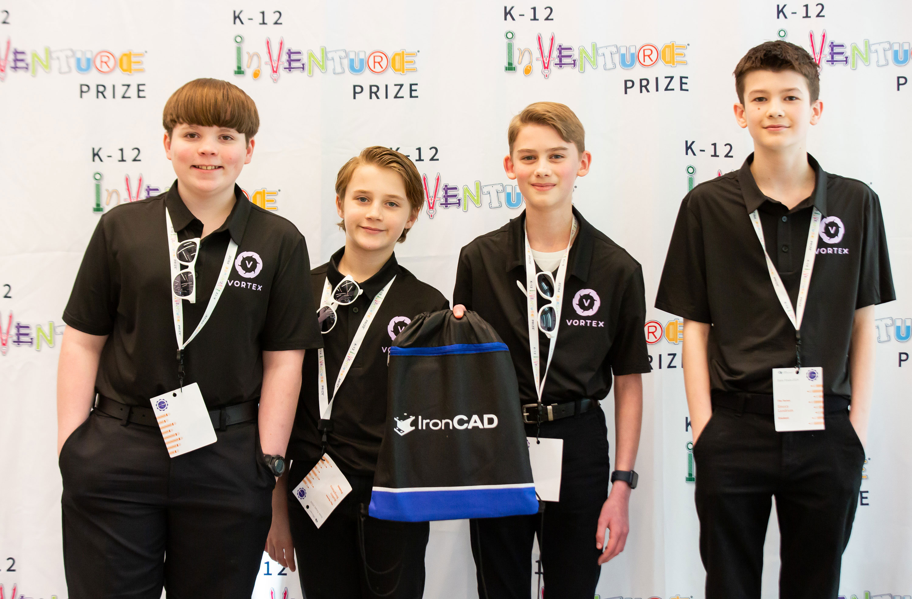 Four smiling students holding an IronCAD bag