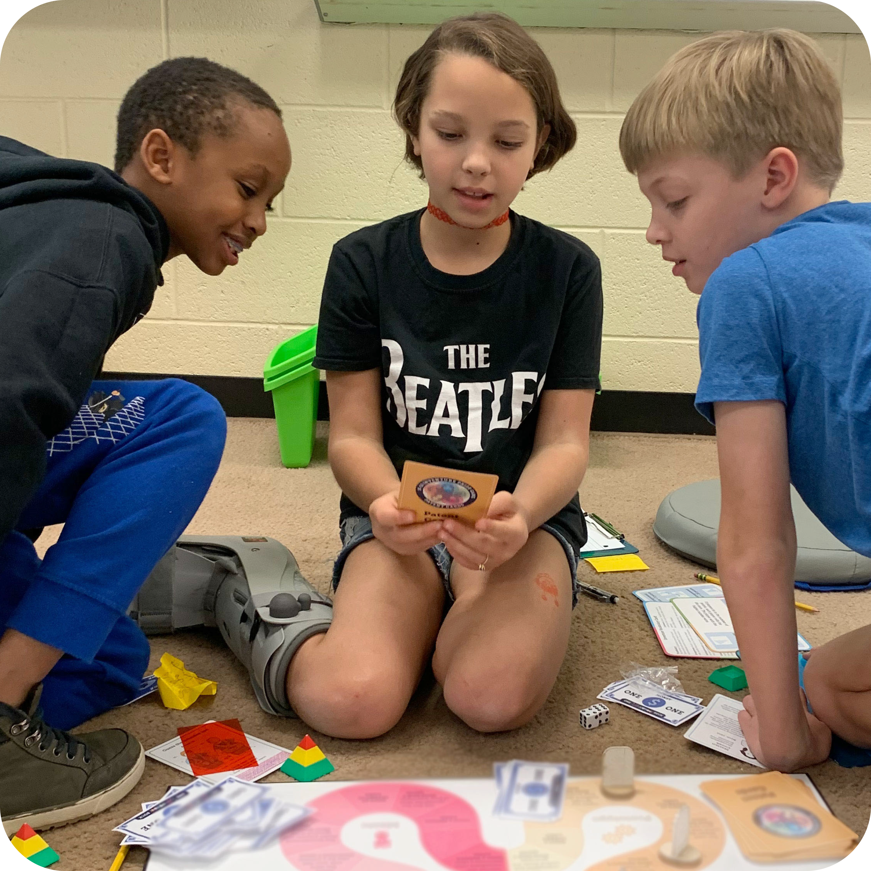 Three students looking at a card for a board game